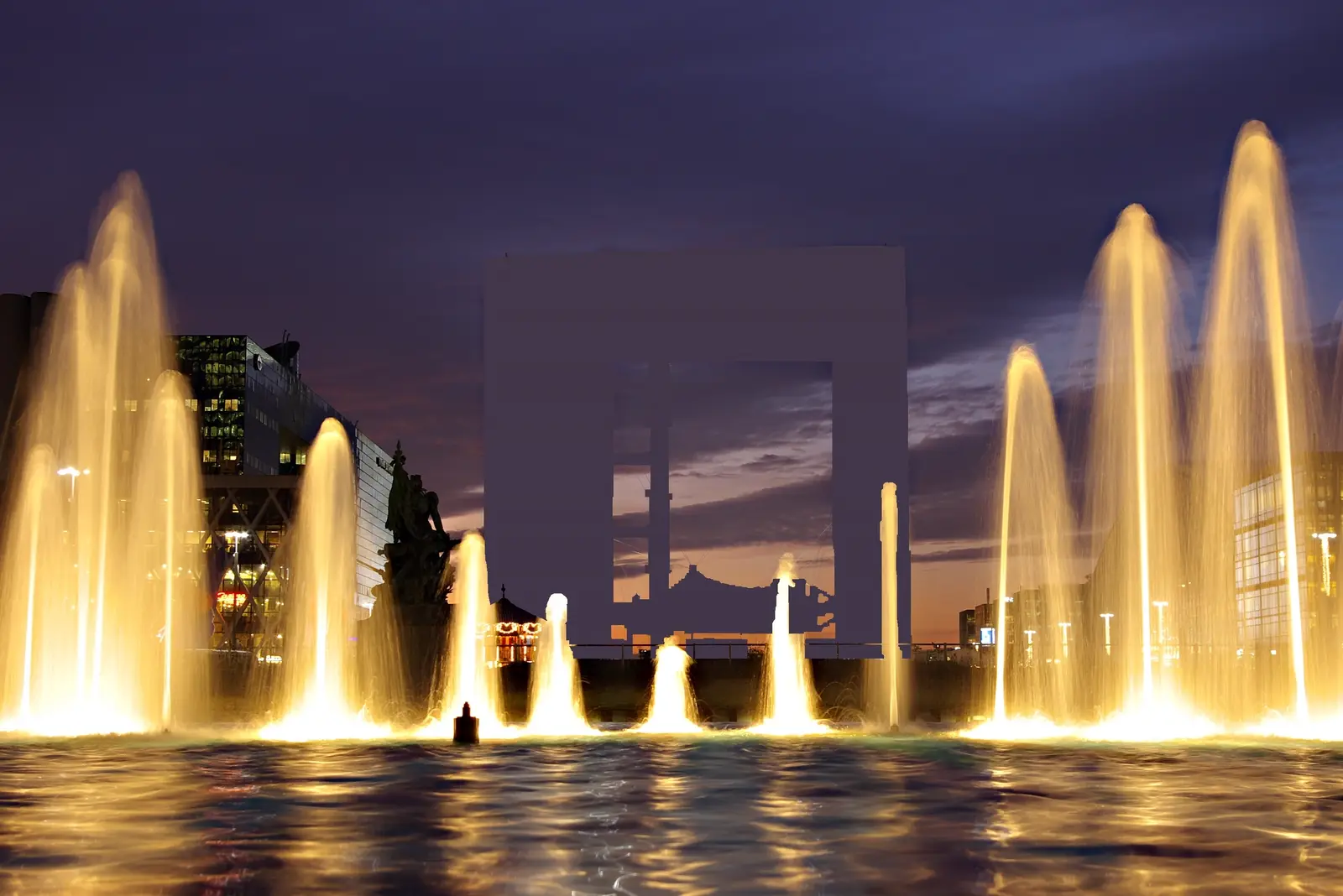 Les fontaines illuminées au pied de la Grande Arche de La Défense